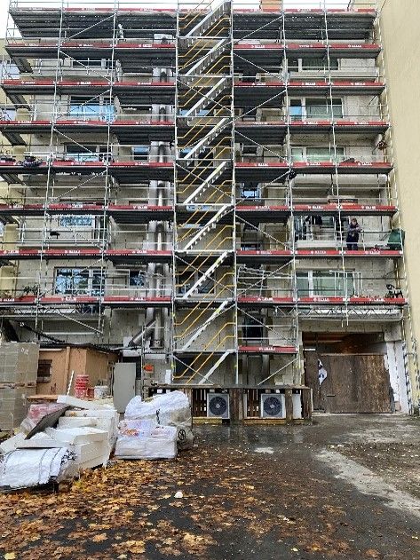 Es wird ein großes Gebäude mit Gerüst und Treppen errichtet.