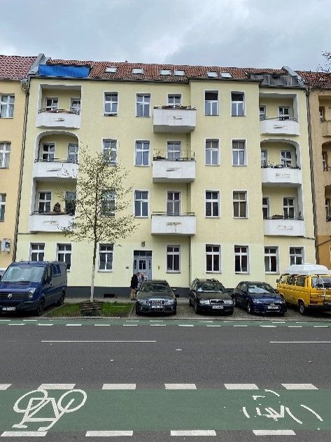 Ein gelbes Gebäude mit davor geparkten Autos