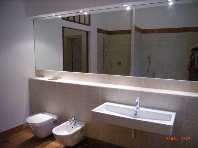 Ein Badezimmer mit großem Spiegel und zwei Waschbecken