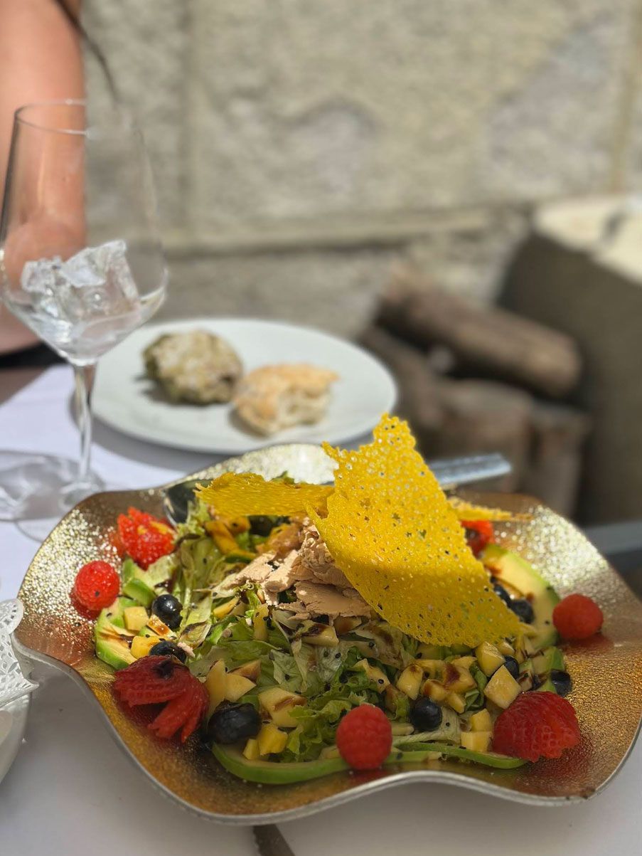 Un primer plano de una ensalada en un plato sobre una mesa.