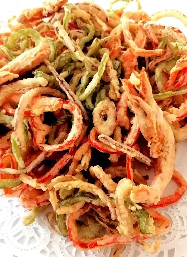 Un primer plano de verduras fritas en un plato blanco.