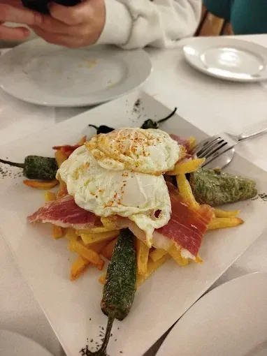 Una persona está tomando una fotografía de un plato de comida sobre una mesa.