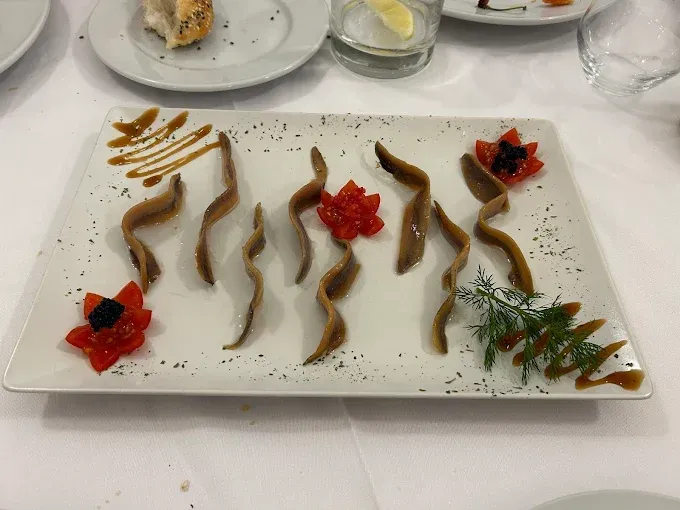 Un plato blanco cubierto con una variedad de alimentos sobre una mesa.