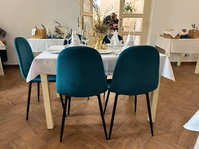 Una mesa de comedor con sillas azules y un mantel blanco.