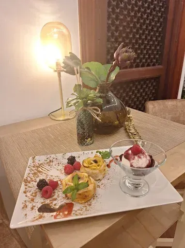 Un plato de comida con un vaso de helado sobre una mesa.