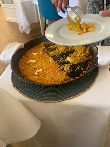 Una persona está poniendo arroz en un plato con un tenedor.