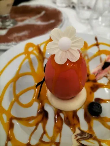 Un primer plano de un postre con una flor encima.