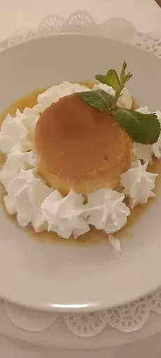 Un plato blanco cubierto con un postre y crema batida.