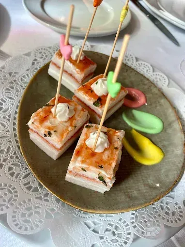 Un plato de comida con sándwiches en palillos sobre una mesa.
