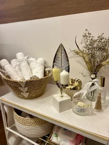 Una mesa con una cesta de toallas y una vela sobre ella.