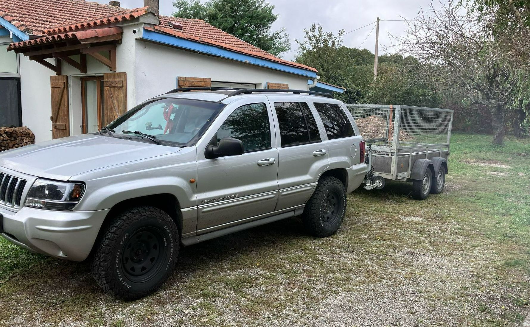 Une voiture avec sa remorque pour transporter les déchets d'élagage