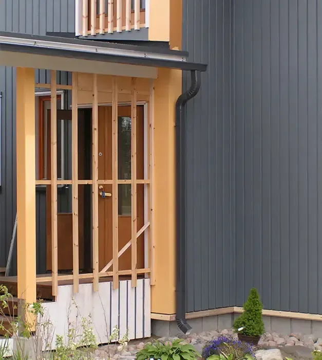 Valmis sadevesijärjestelmän poistoputki ja kaivo, joka ohjaa vedet turvallisesti pois rakennuksen vierustalta.