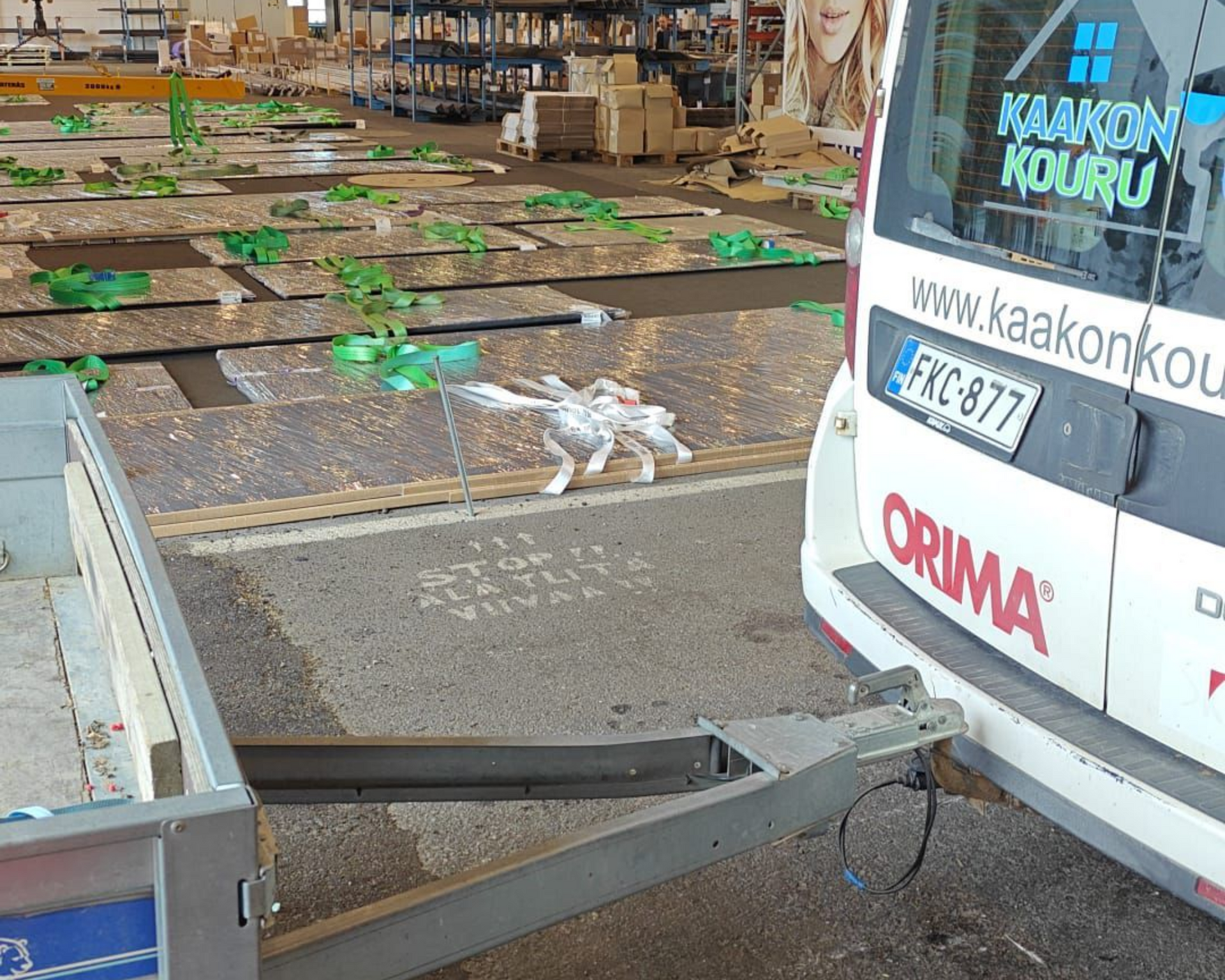 Kuorma-auton perävaunu purkaa vihreitä laatikoita varastossa