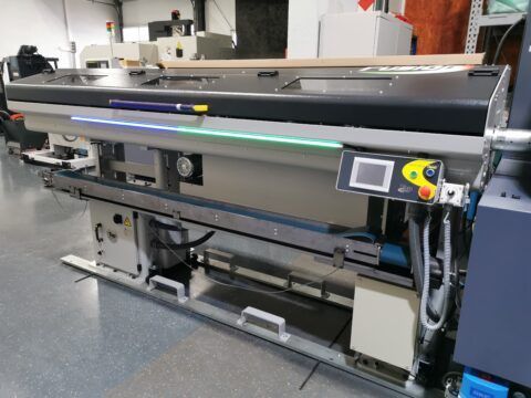 Große industrielle Druckmaschine mit Bedienfeld und Beleuchtung.