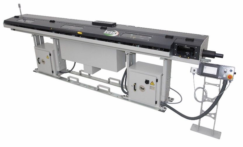 Industriemaschine mit einem langen, schwarzen Bauteil auf einem Metallrahmen, einschließlich eines Bedienfelds.
