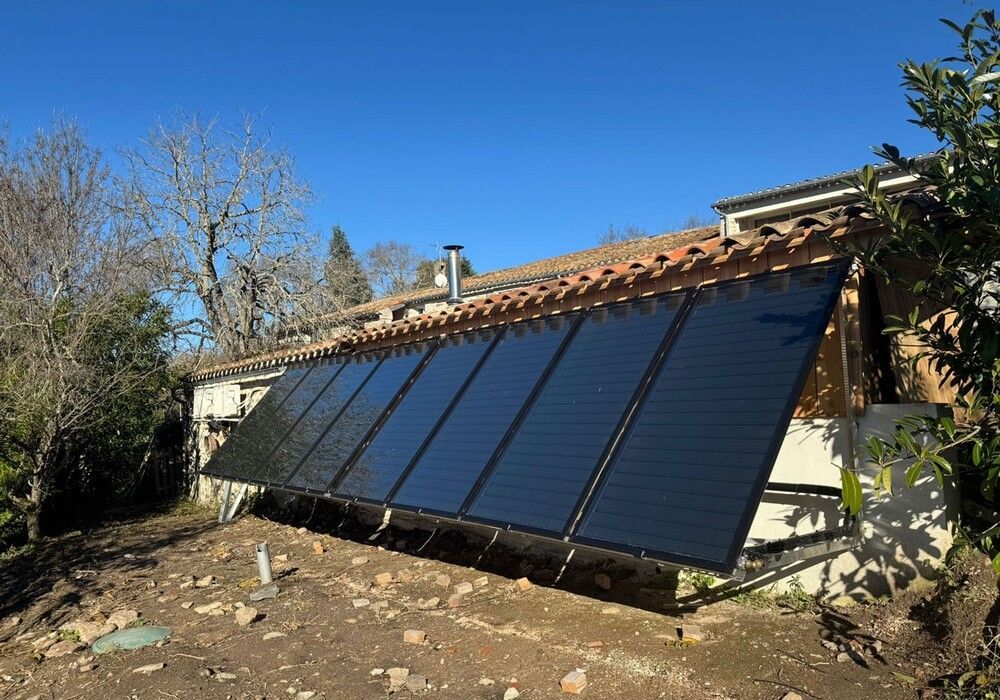 Des panneaux solaires sur un toit, le soleil brillant de mille feux en arrière-plan.