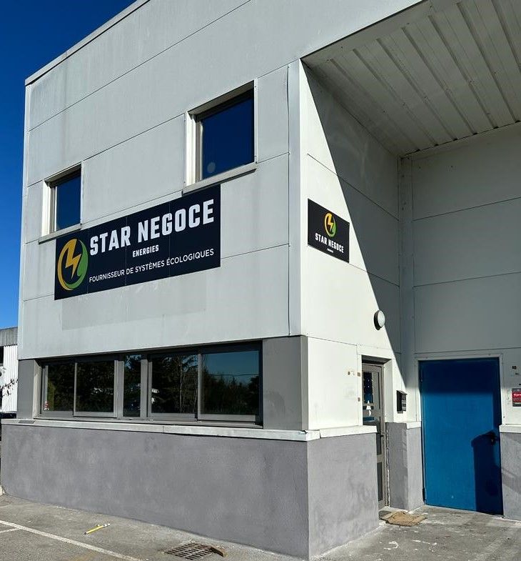 Des panneaux solaires installés sur un toit reflètent la lumière éclatante du soleil sur un ciel bleu.