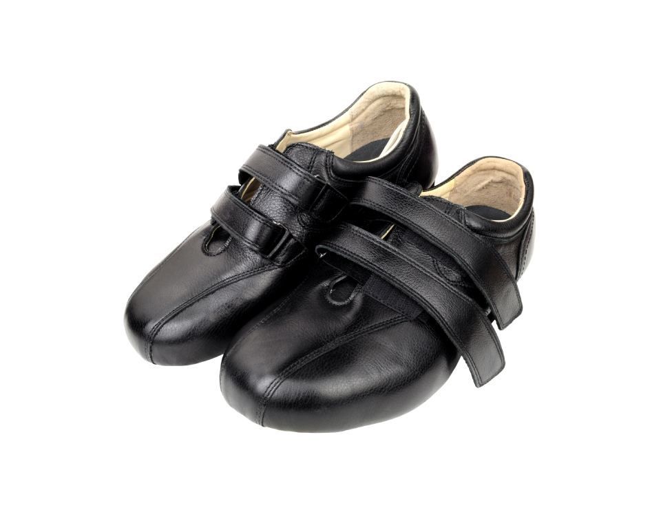 Ein Paar schwarze Schuhe mit Klettverschluss auf weißem Hintergrund.