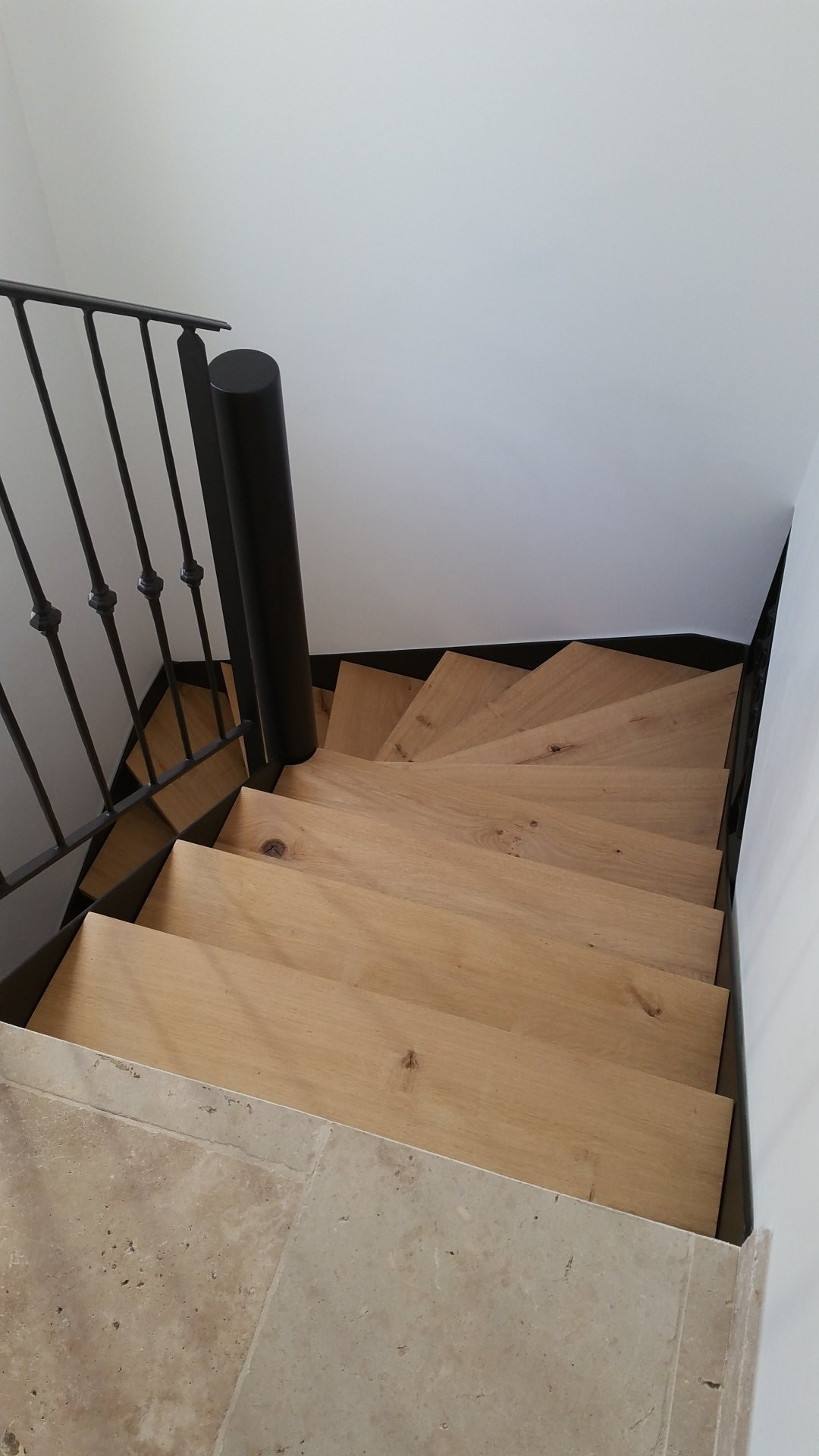 Escalier en bois en colimaçon avec une rampe en métal