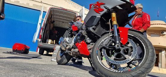 Una motocicleta está estacionada al costado de la carretera al lado de una camioneta.