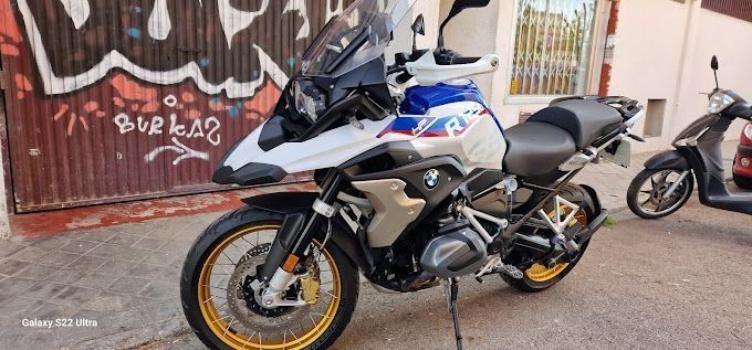 Una motocicleta está estacionada frente a un edificio con grafitis.