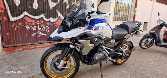 Una motocicleta está estacionada frente a un edificio con grafitis.