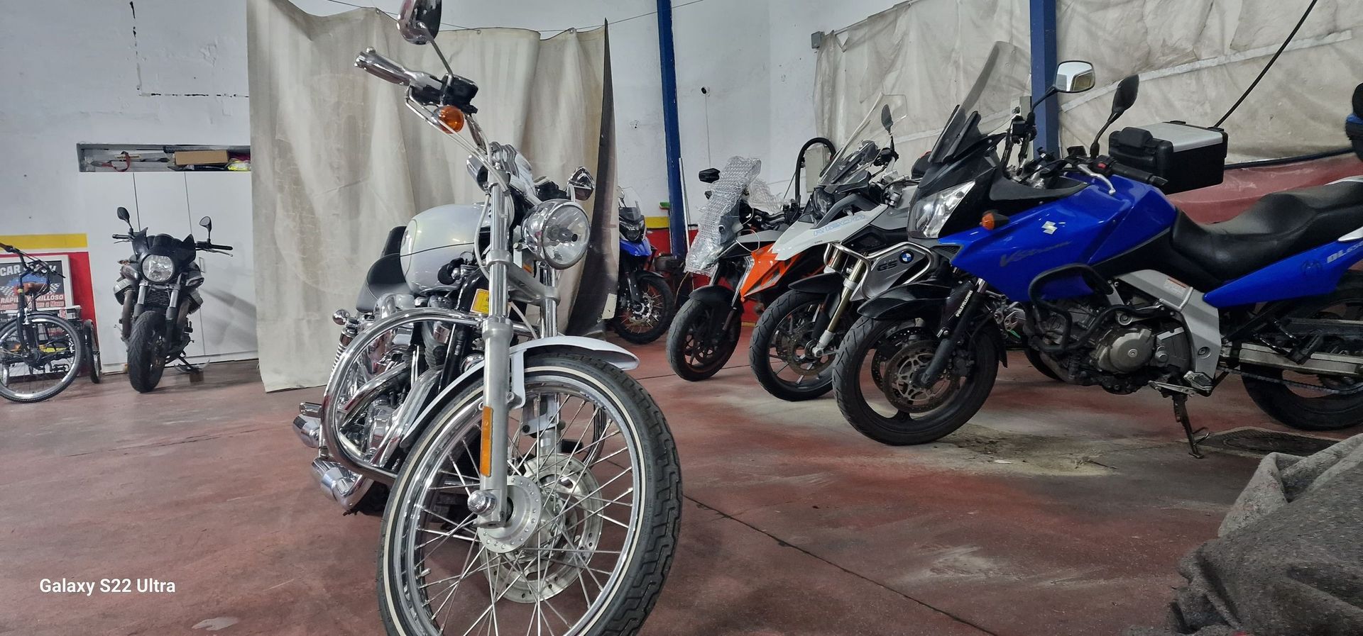 Una fila de motocicletas están estacionadas en un garaje.