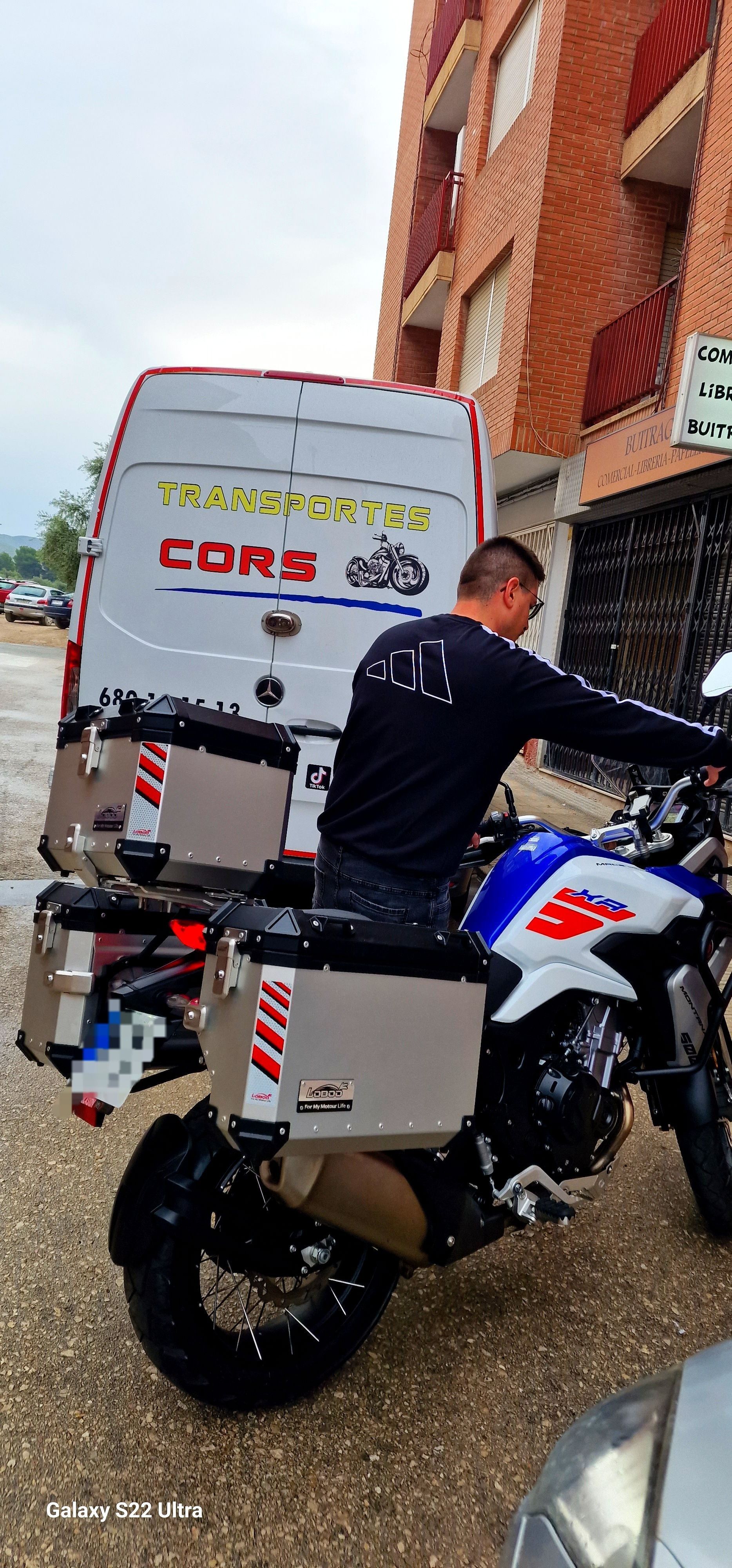 Un hombre conduce una motocicleta al lado de una camioneta.