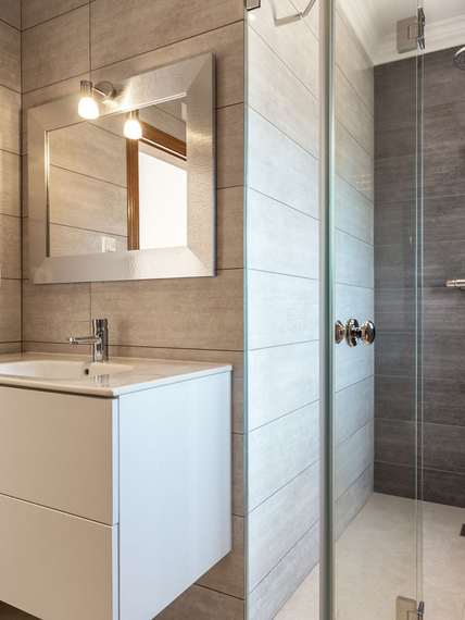 Meuble-lavabo moderne avec miroir, appliques murales et cabine de douche en verre