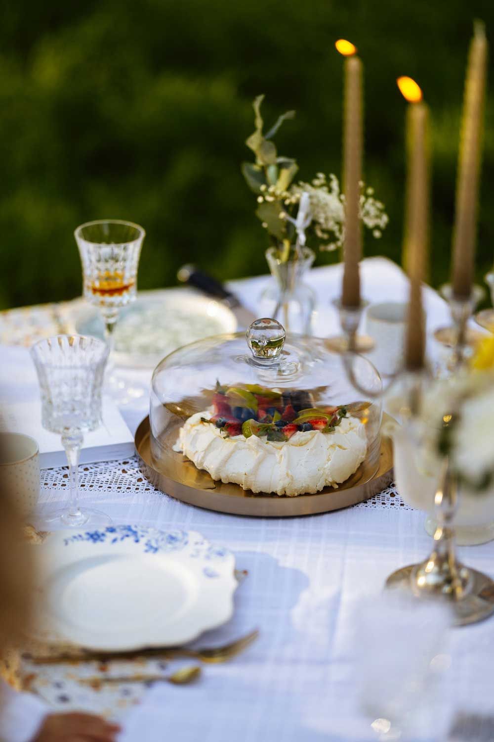 Una mesa con platos, velas y un pastel encima.