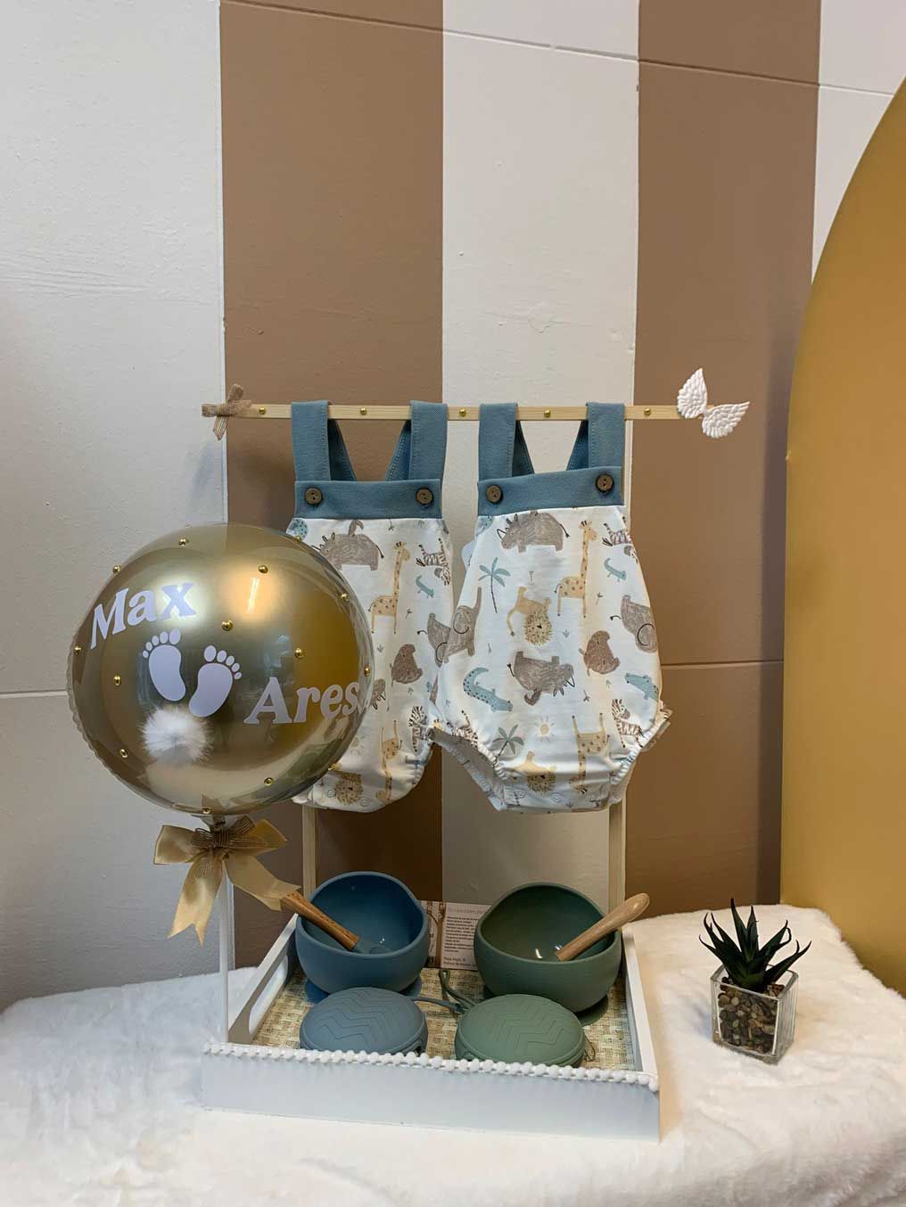 Un globo con la huella del pie de un bebé está sobre una mesa al lado de una bandeja con cuencos.