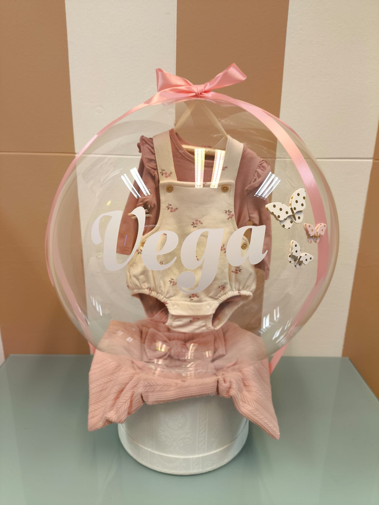 Un globo transparente con el nombre vega escrito en él está sobre una mesa.