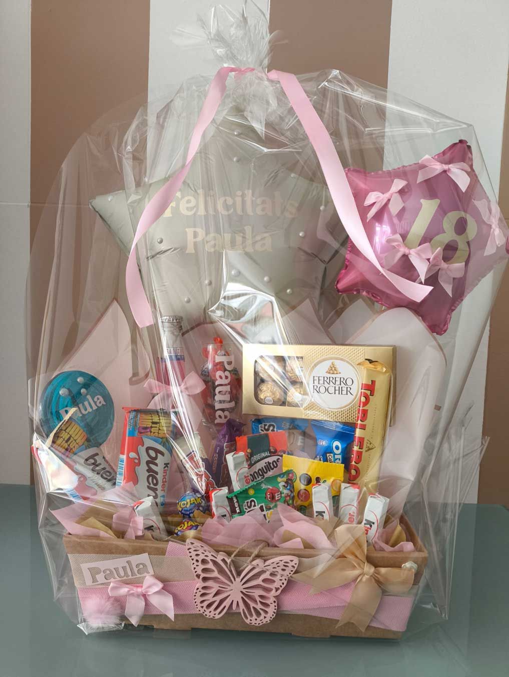 Una canasta llena de dulces, globos y una almohada.