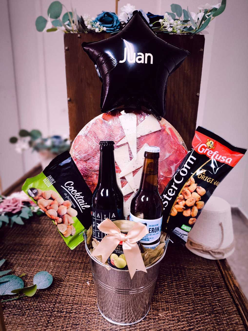 Un balde lleno de comida y un globo con el nombre juan.