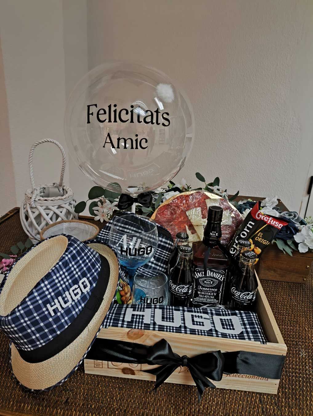 Una bandeja con un sombrero, botellas de alcohol, un globo y un globo con el nombre hugo.