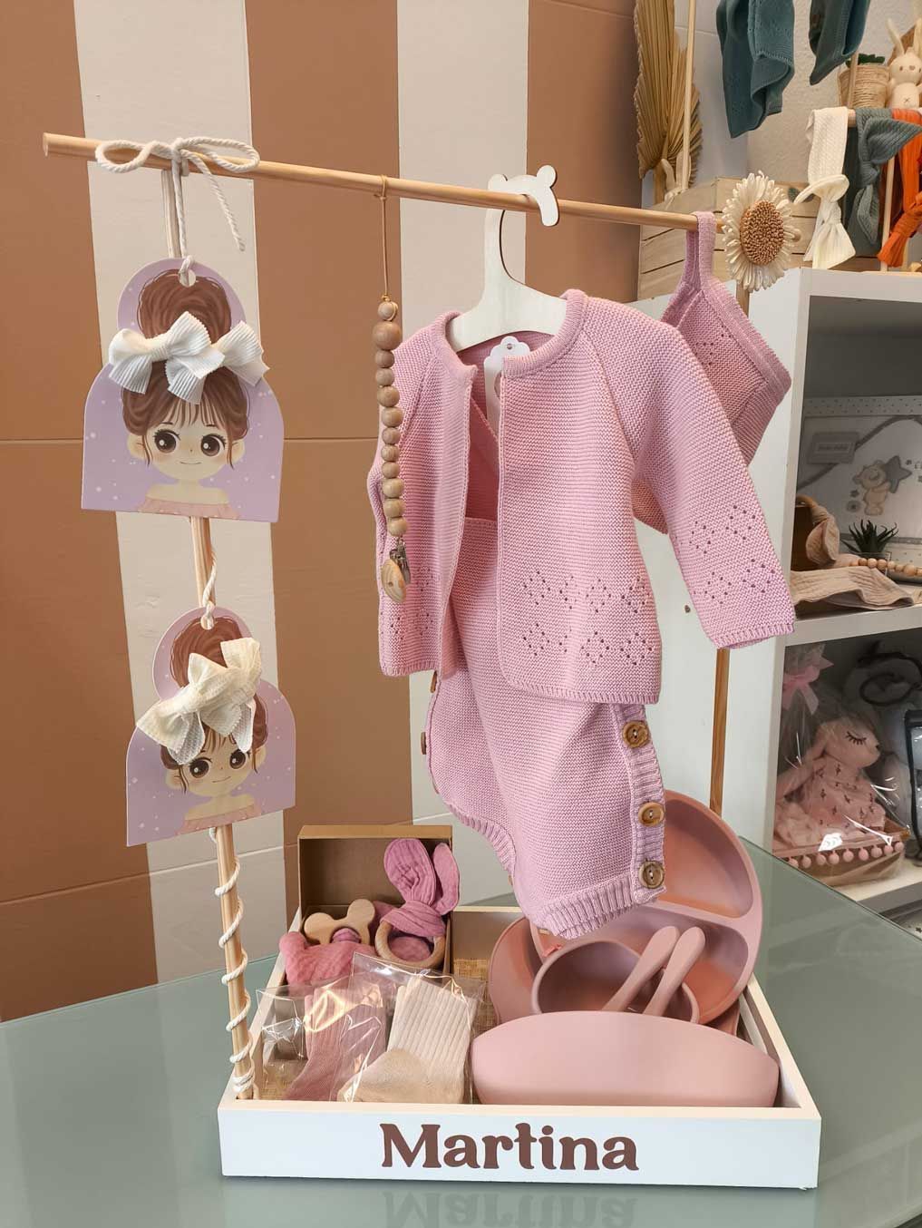La ropa de un bebé se exhibe en una bandeja con el nombre Martina.
