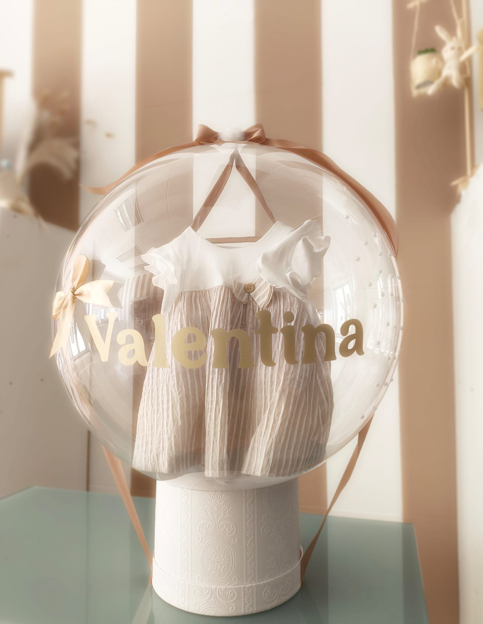 Un globo con un vestido dentro con el nombre Valentina.