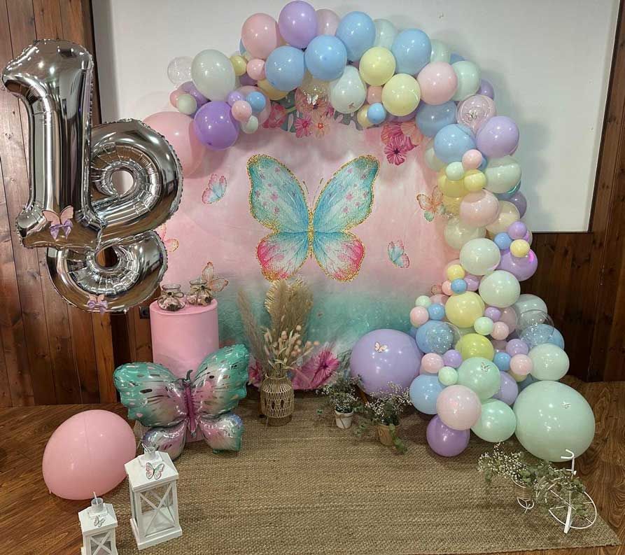 Una fiesta de cumpleaños temática de mariposas con globos y velas.