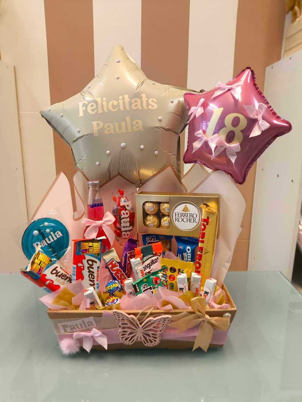 Una canasta llena de dulces y globos para un cumpleaños número 18.