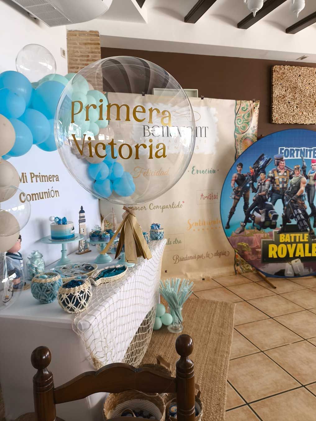 Una habitación con una mesa y sillas y globos encima.