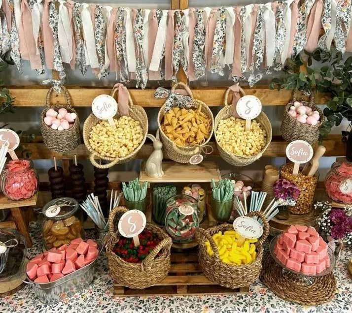 Una mesa cubierta de cestas llenas de dulces y bocadillos.