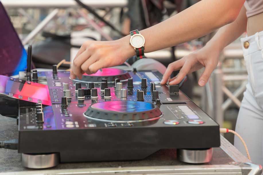 Una mujer está tocando música en un mezclador de DJ.