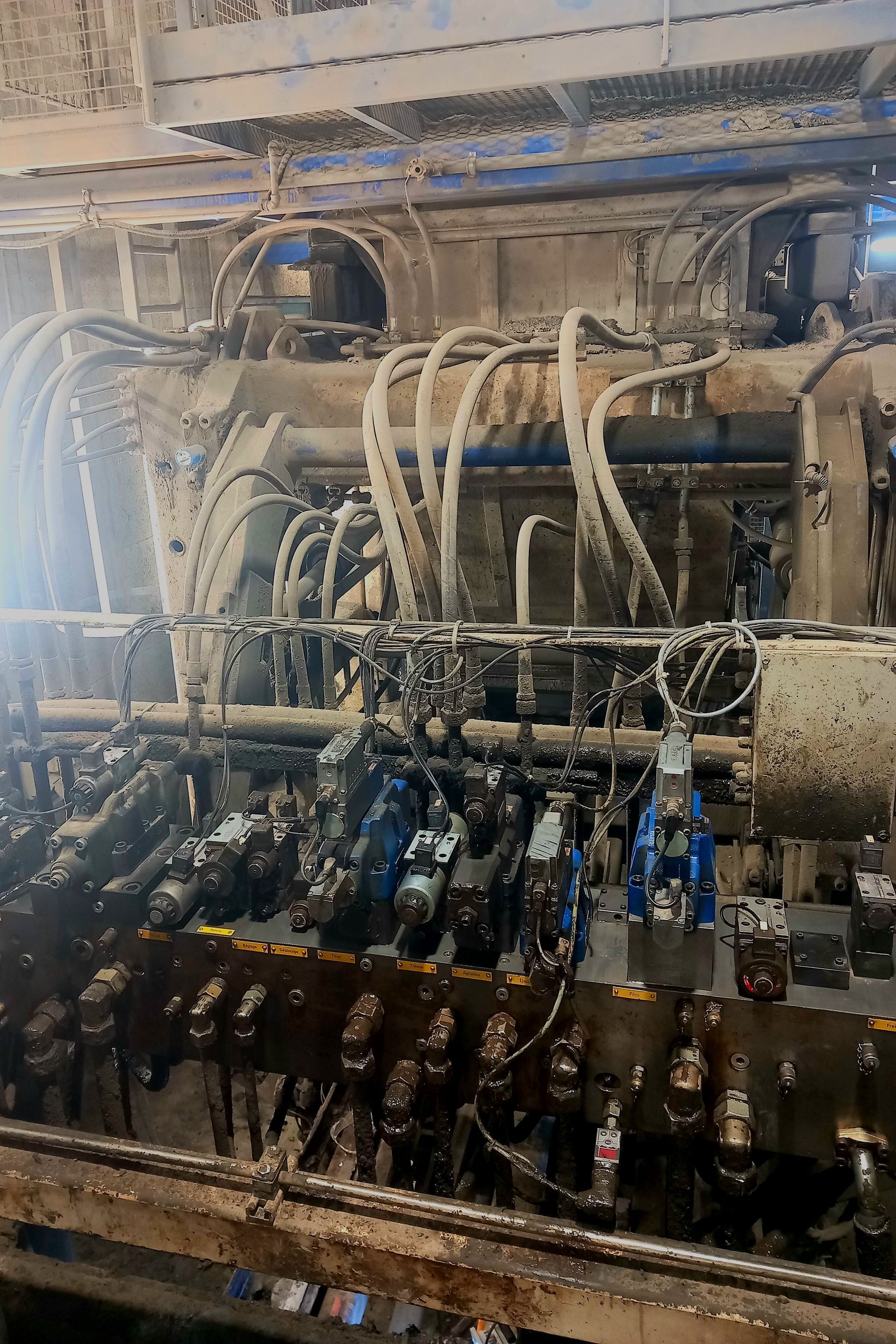 Machines industrielles avec rangées de tuyaux et de vannes dans un environnement d'usine