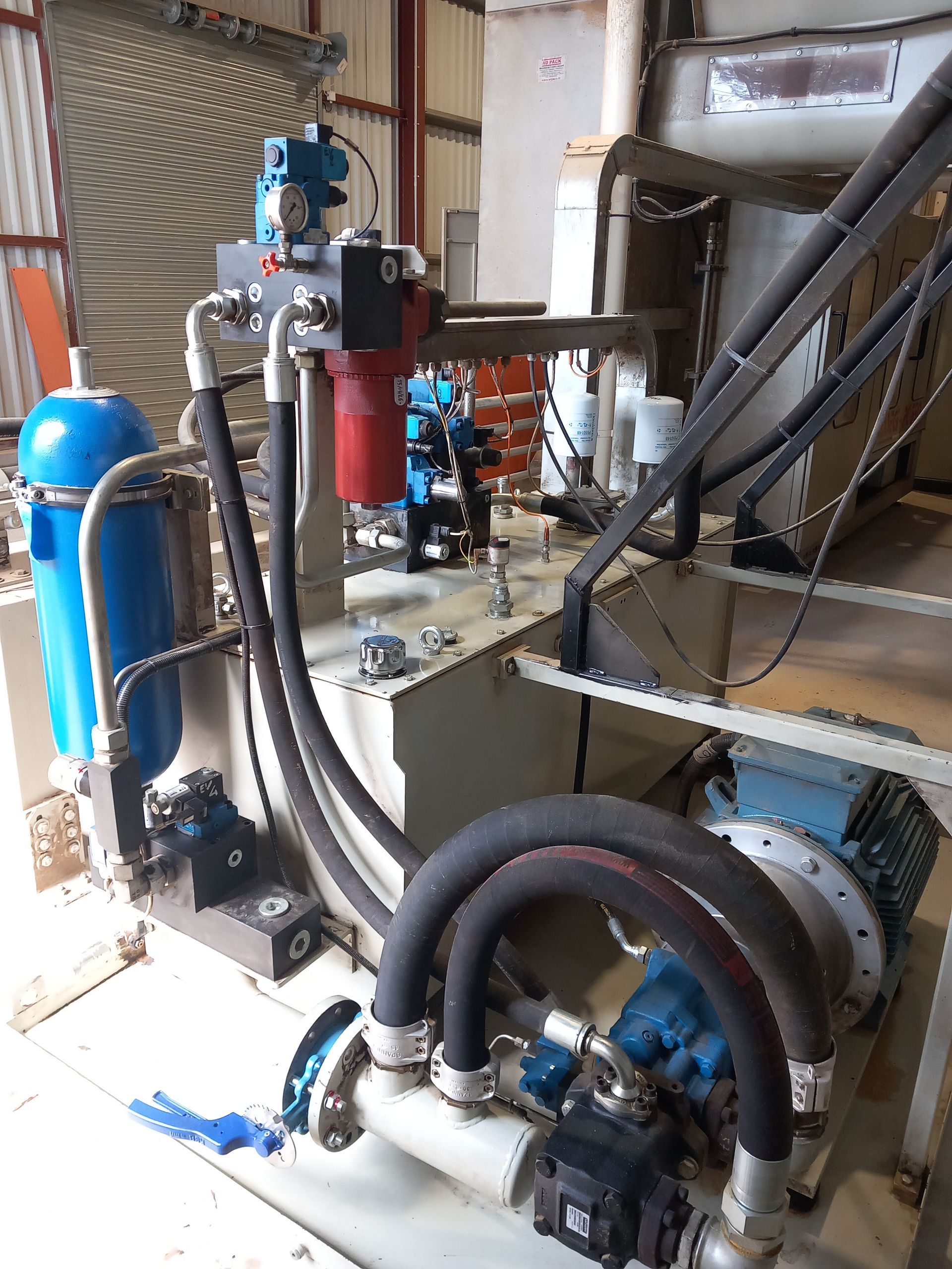 Machines industrielles avec réservoirs bleus, tuyaux et canalisations à l'intérieur d'un atelier