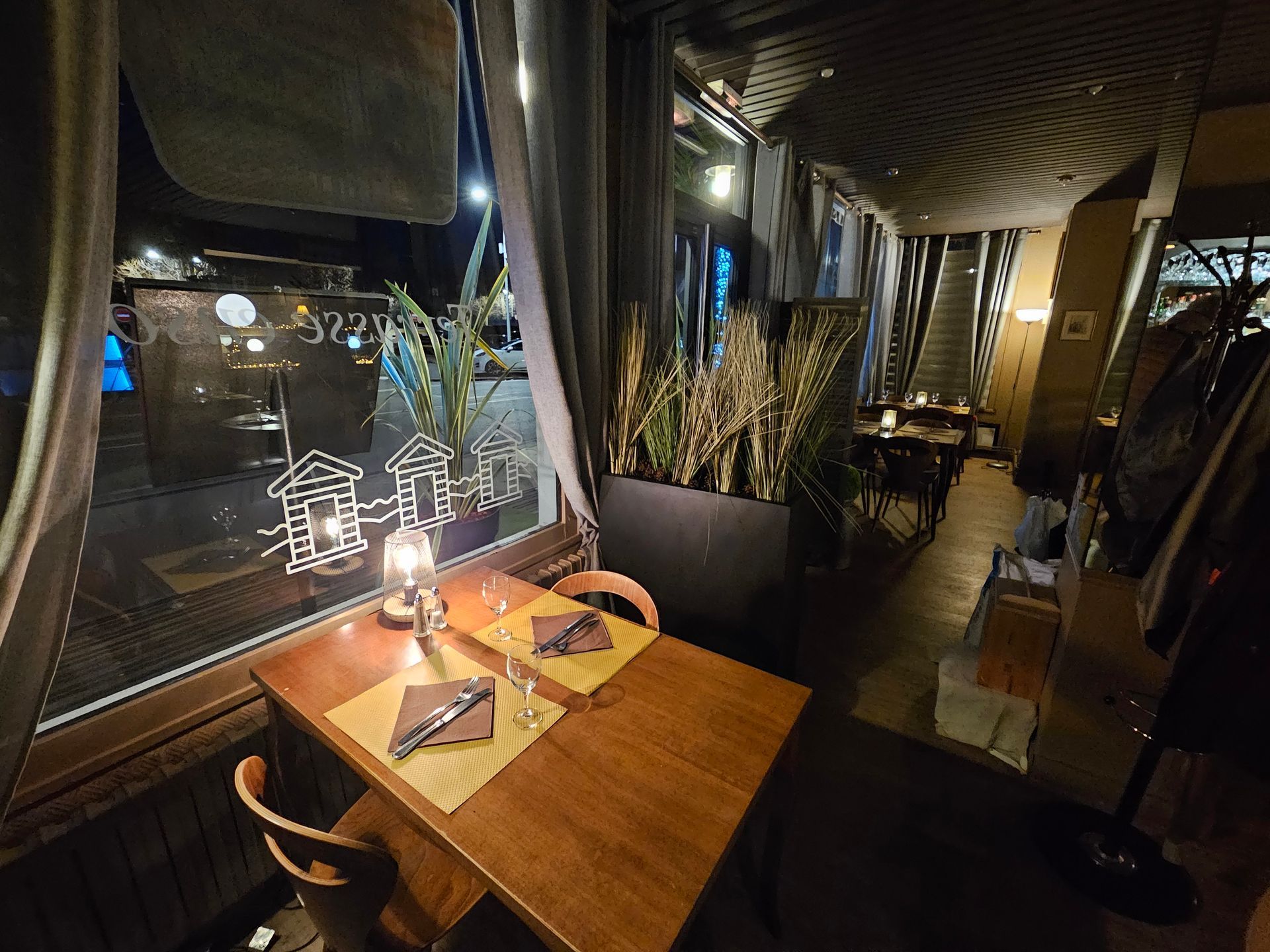 Coin fenêtre de la crêperie et brasserie Les Cabines avec table dressée