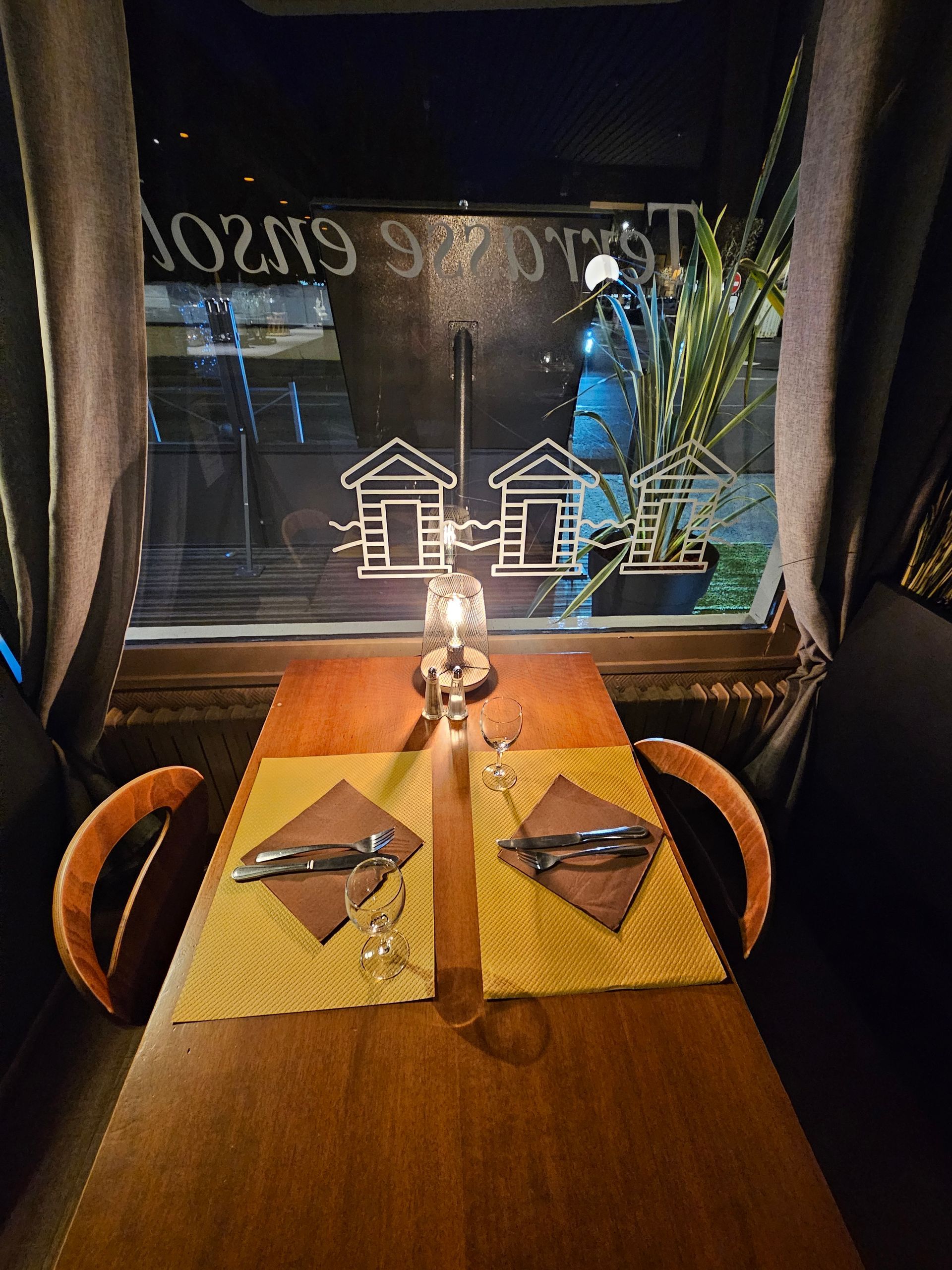 Table de restaurant en tête-à-tête avec vue sur la rue, ambiance intimiste