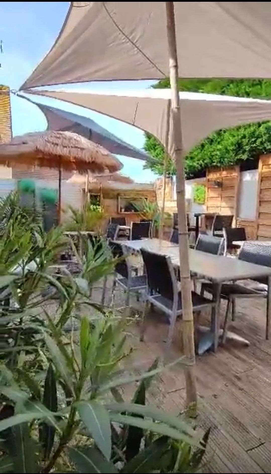 Terrasse extérieure de la crêperie Les Cabines avec une décoration tropicale