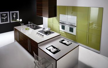 eine Küche mit grünen Schränken und weißen Geräten