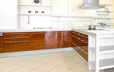 eine Küche mit Holzschränken und weißen Schränken