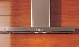 eine Dunstabzugshaube hängt an einer Holzwand in einer Küche .